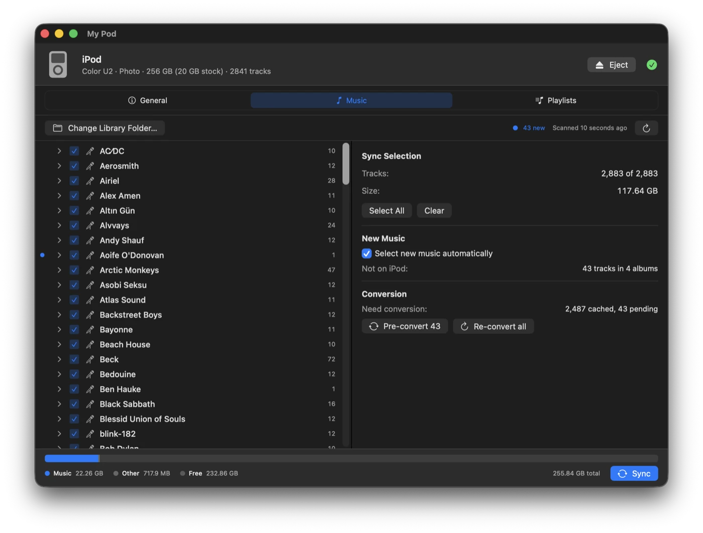 The Music tab: a scrollable list of artists with checkboxes, a dot marking artists not yet on the iPod, and a side panel showing sync selection, new music, and conversion status.
